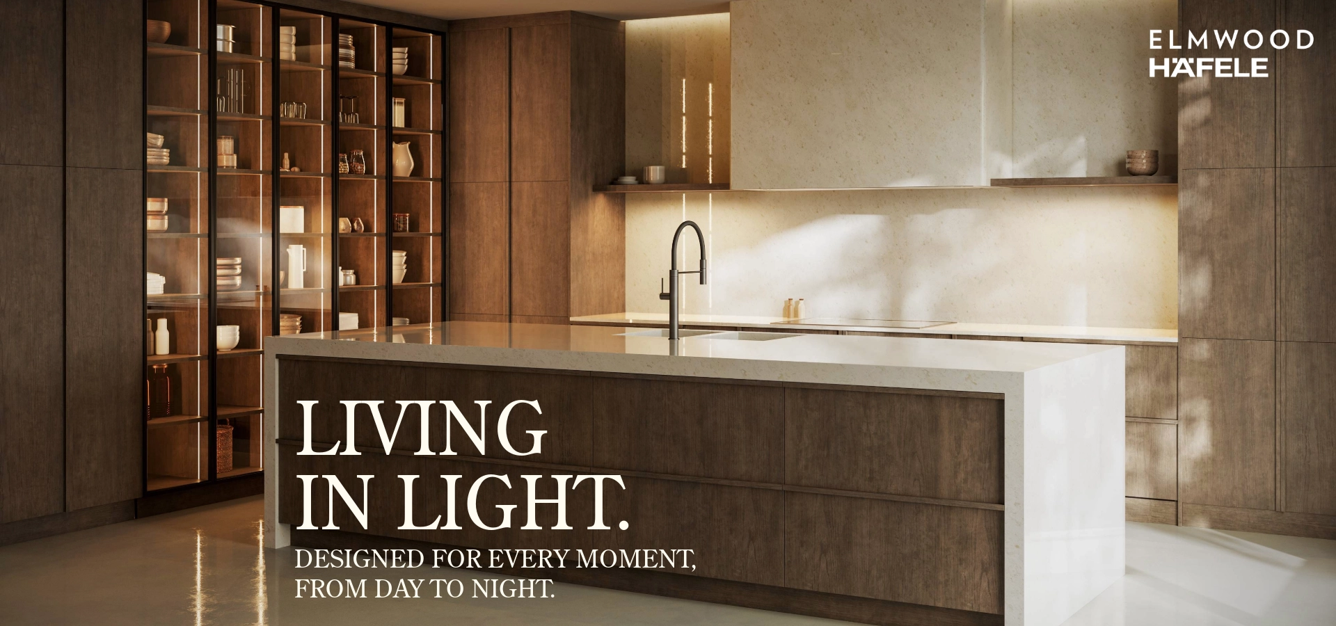 Modern luxury kitchen with Elmwood cabinetry and Häfele integrated LED cabinet lighting highlighting glass-front displays and a minimalist island.